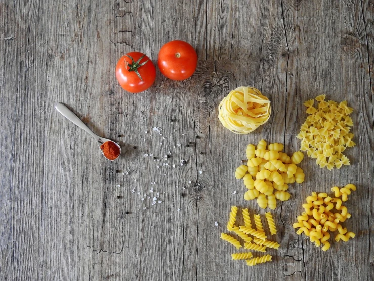 a wooden table topped with pasta and tomatoes, process art, high quality product photo, polka dot, high quality image”