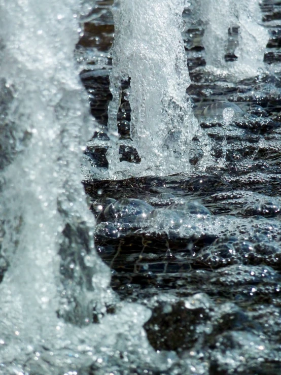 a close up of a fountain with water coming out of it, a macro photograph, by Cherryl Fountain, process art, pillars of ice background, babbling brook, watermark:-1, shot on sony a 7