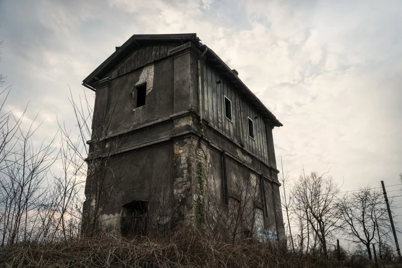 a tall tower sitting on top of a grass covered hillside, a portrait, by Adam Szentpétery, shutterstock, abandoned house interior, very scary photo, abandoned warehouse, the photo shows a large