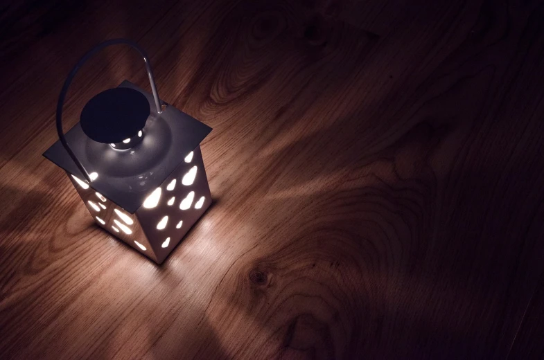 a lantern sitting on top of a wooden table, light and space, soft lighting from above, photo taken at night, istock, volumetric light and shadow