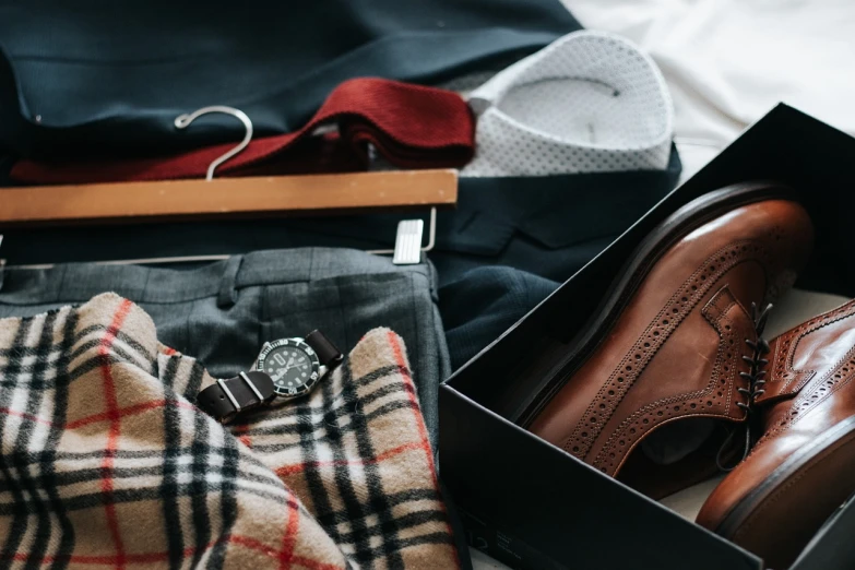 a pair of shoes and a watch in a box, pexels, assemblage, tartan garment, stock photo, open v chest clothes, warm color clothes