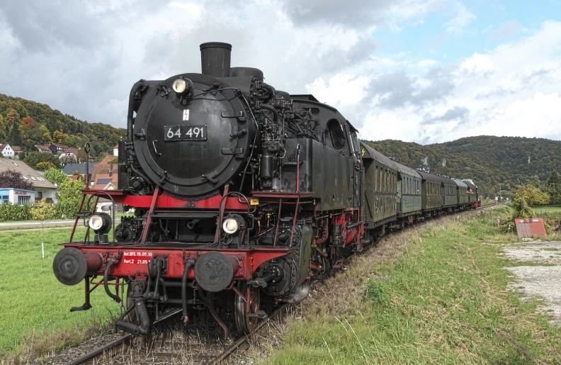 a black and red train traveling down train tracks, a picture, by Jörg Immendorff, shutterstock, preserved historical, big engine, black forest, 64x64