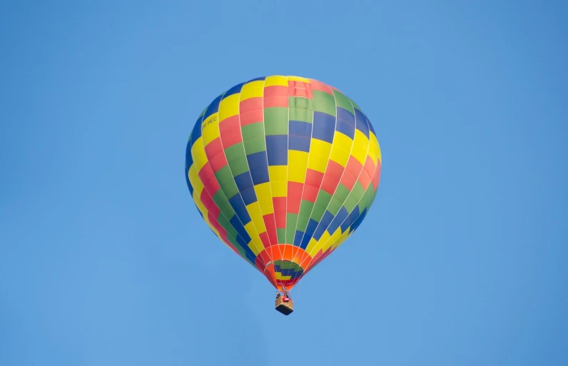 a colorful hot air balloon flying through a blue sky, a picture, by Dave Melvin, shutterstock, set photo, stock photo