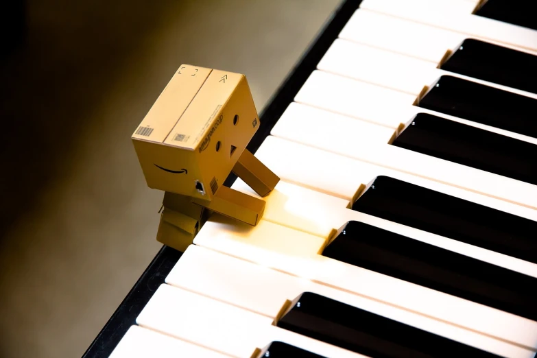 a smiley face sitting on top of a piano keyboard, a picture, by Ottó Baditz, tumblr, robot made of a cardboard box, ivory, beautiful wallpaper, musical instruments