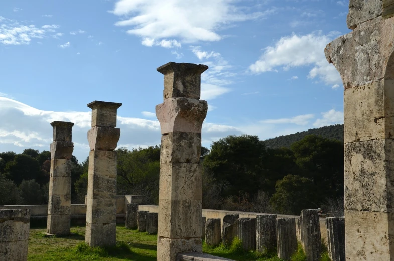 a row of stone pillars sitting on top of a lush green field, by Alexis Grimou, flickr, les nabis, alexandros pyromallis, pillars on ceiling, lorica segmentum, lourmarin