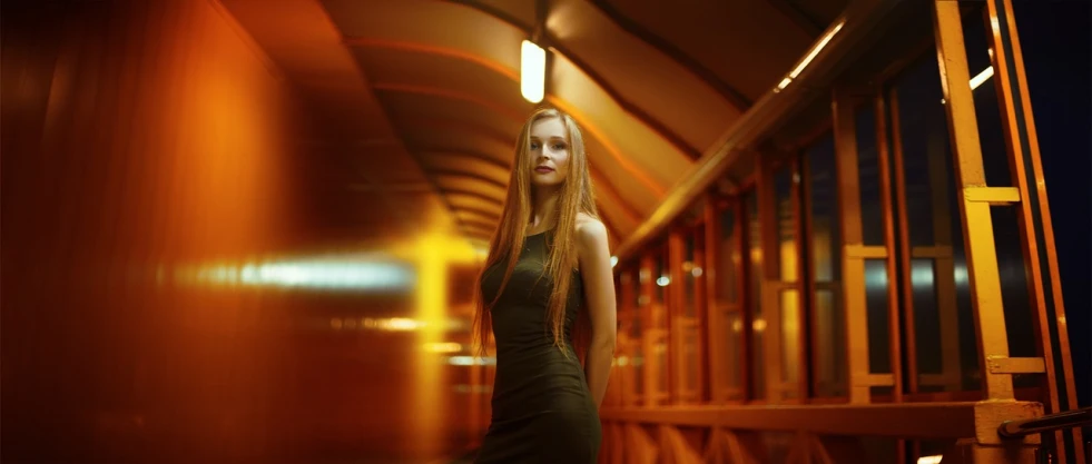 a woman in a black dress standing in a hallway, by Hristofor Zhefarovich, tumblr, digital art, long ginger hair, lone girl waiting for the train, bokeh volumetric lighting, beautiful yellow woman