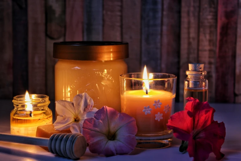 a couple of candles sitting on top of a table, shutterstock, jar of honey, glowing flowers, bathed in the the glow of a fire, mid morning lighting