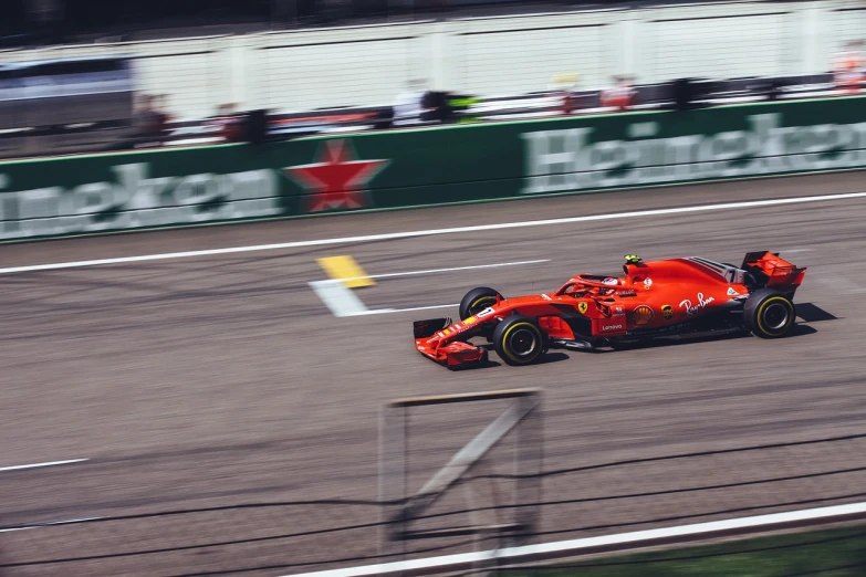 a man driving a red race car on a track, a photo, by Alexander Fedosav, pexels, max verstappen, stock photo, aerodynamic body, f 1 driver charles leclerc