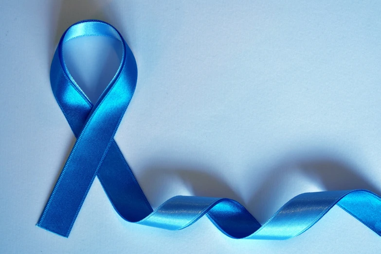 a blue ribbon laying on top of a white surface, by Stefan Gierowski, pixabay, the cure for cancer, un dia de paz, 30 year old man, monitor