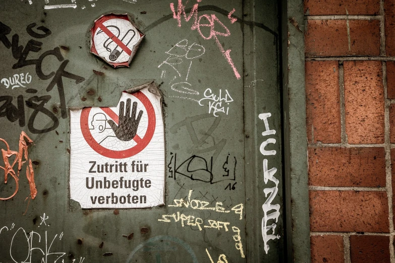 a close up of a door with graffiti on it, a poster, by Oskar Lüthy, flickr, rubbing hands!!!, forbidden information, stick poke, german