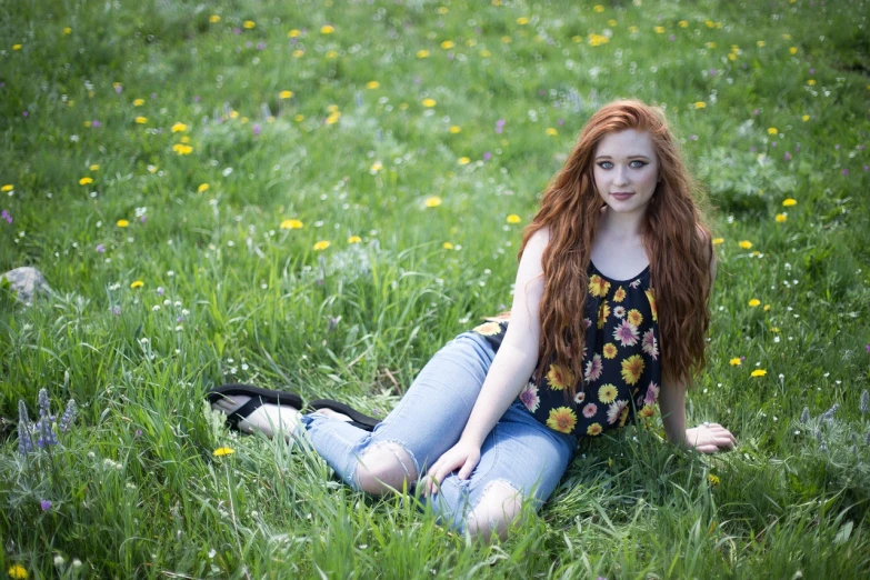 a beautiful young woman sitting on top of a lush green field, a portrait, flickr, cute young redhead girl, floral clothes, kim possible, with long hair and piercing eyes