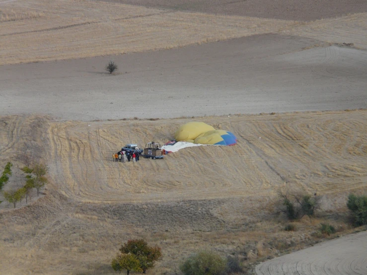 a group of people in a field with a parachute, by Muggur, flickr, in spain, visible from afar!!, mid fall, poor quality