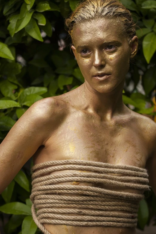 a woman with a rope wrapped around her chest, a portrait, inspired by Henry Scott Tuke, flickr, gold bodypaint, steven mccurry portrait, outdoor photo, sweaty 4 k