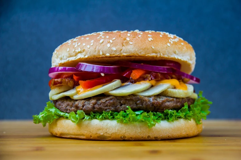 a hamburger sitting on top of a wooden table, a picture, by Jan Rustem, shutterstock, hyperrealism, extra onions and ketchup, high detail product photo, stock photo