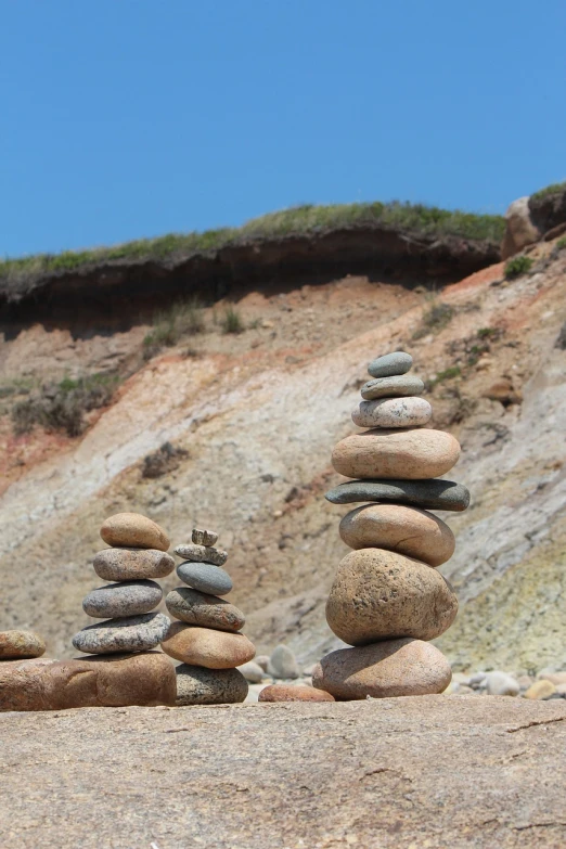 a group of rocks stacked on top of each other, land art, tourist photo, rhode island, rock and sand around, set photo