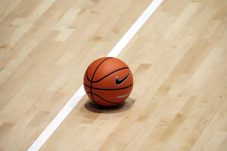 a basketball ball sitting on top of a wooden floor, by Niko Henrichon, dribble, lined up horizontally, fibres trial on the floor
