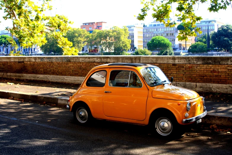 an orange car parked on the side of the road, a picture, inspired by Francesco Filippini, flickr, renaissance, rome backdrop, square, yellow colors, incredibly cute