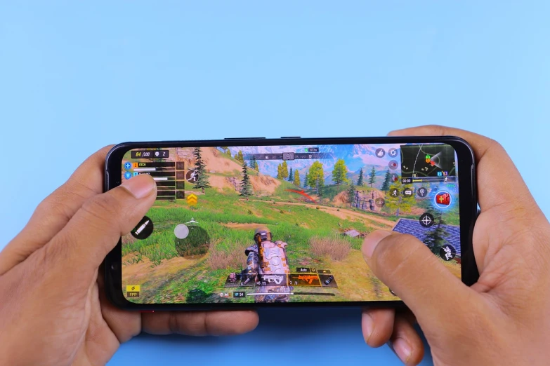 a close up of a person holding a cell phone, a picture, shutterstock, realism, fps game concept, with a blue background, gaming table, gameplay video