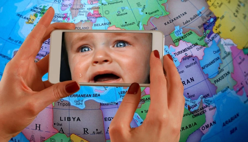 a close up of a person holding a cell phone, a picture, regionalism, little kid, crying! android! woman, map, middle east