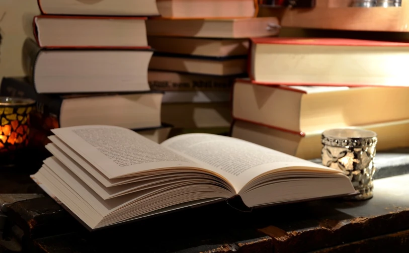 a stack of books sitting on top of a table, by Thomas Häfner, open book page, in a library, dynamic closeup, in the evening