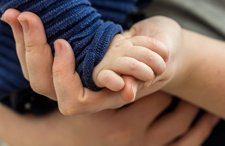 a close up of a person holding a baby's hand, incoherents, hugging his knees, lachlan bailey, blue soft details, young boy