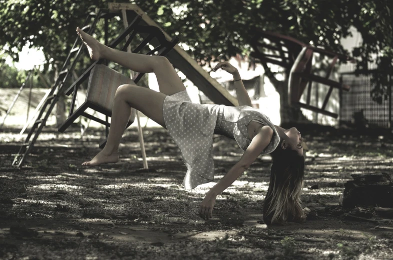 a woman laying on a swing in a park, a portrait, inspired by Dorothea Tanning, tumblr, contemporary dance, fotografia, shaded, concept photoset