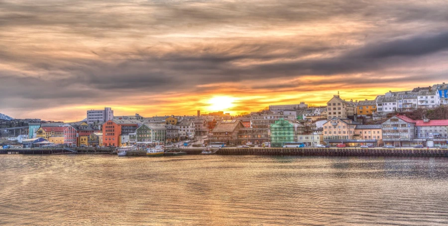 a large body of water filled with lots of buildings, by Ejnar Nielsen, flickr, fur hdr, colorful sunset!!, hamar, port scene background