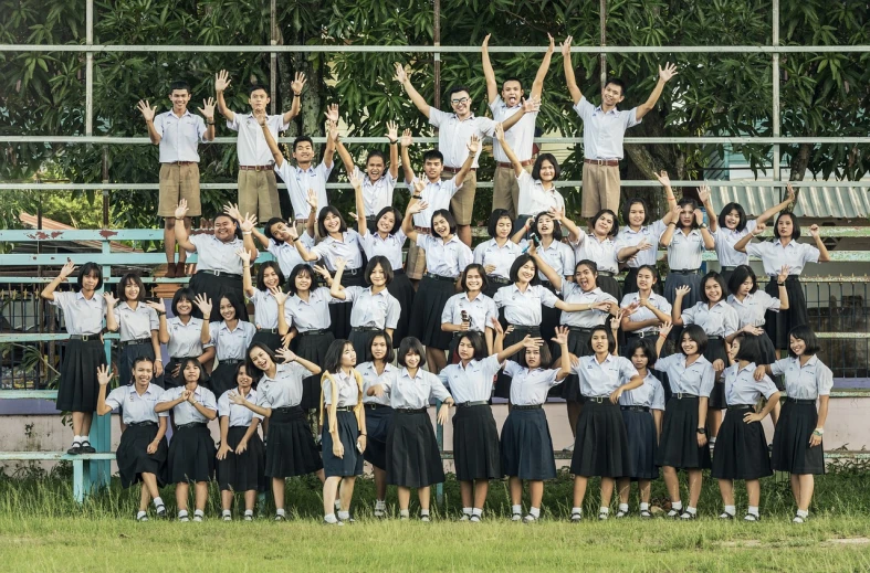 a group of people standing in front of a blea blea blea blea blea blea blea blea blea b, shutterstock, academic art, thailand, pose(arms up + happy), jk uniform, yearbook photo
