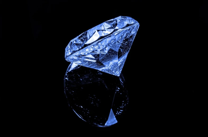 a close up of a diamond on a black surface, a hologram, pixabay, a daub of cold blue, viewed from the side, 2000s photo