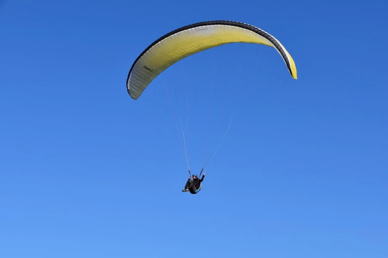 a person that is in the air with a parachute, a picture, hurufiyya, clear blue sky, buggy, viewed in profile from far away, beautiful black blue yellow