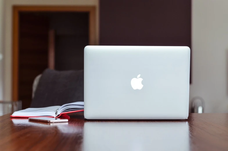 a laptop computer sitting on top of a wooden table, by Romain brook, pexels, with apple, glossy white, back - shot, immaculately detailed