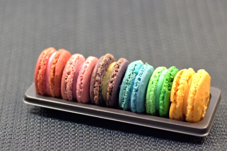 a close up of a tray of macarons on a table, inspired by Charles Le Roux, flickr, rainbow colored, panorama, boucheron, in a row