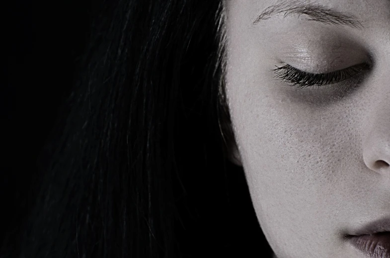 a close up of a woman with her eyes closed, a black and white photo, realism, with haunted eyes and dark hair, with a hurt expression, a woman's profile, black eyes and sclera