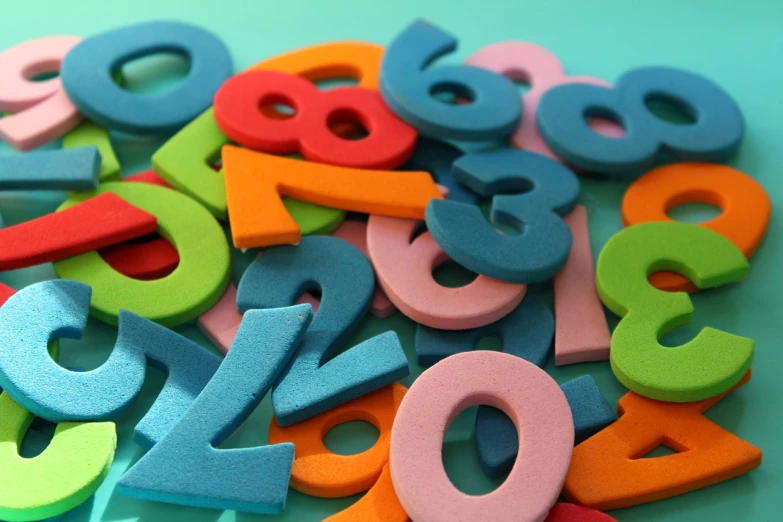 a pile of colorful wooden numbers on a table, 1786560639, background image, felt, brand colours are green and blue
