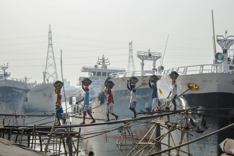 a group of people walking across a bridge over a body of water, a portrait, by Richard Carline, flickr, dhaka traffic, shipyard, high res photo, vessels