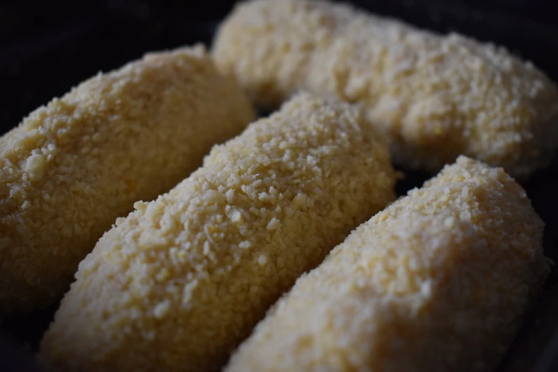 a close up of some food on a plate, menhirs, fluffy, on a dark background, sicilian