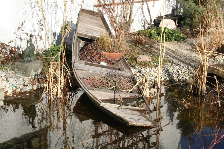 a wooden boat sitting on top of a body of water, a picture, by Joseph von Führich, flickr, land art, against a winter garden, dilapidated, gardening, cornucopia