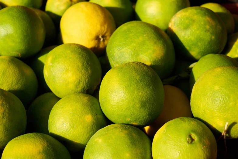 a pile of limes sitting on top of each other, a picture, figuration libre, detailed zoom photo, warm sunshine, high res photo