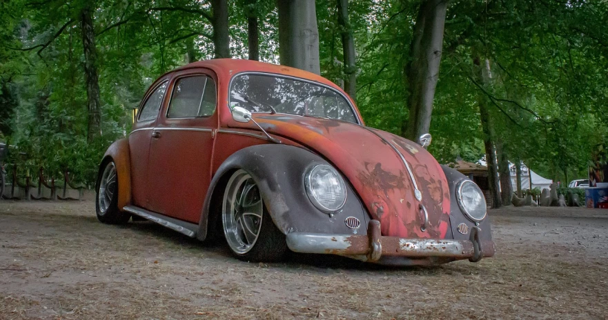 a rusted out car sitting in the middle of a forest, a pastel, by Arnie Swekel, pixabay contest winner, auto-destructive art, horned beetle, front profile shot, drifting, chrome red