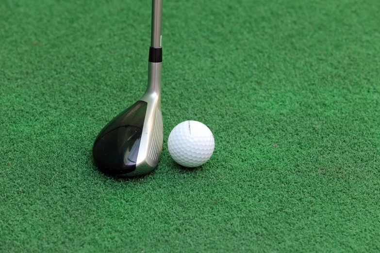 a golf club next to a golf ball on a green surface, inspired by Shirley Teed, 7 0 mm photo