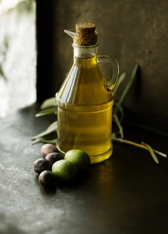 a bottle of olive oil next to some olives, a still life, by Frederik Vermehren, pexels, back lit, old kitchen backdrop angled view, detailed texture, stock photo