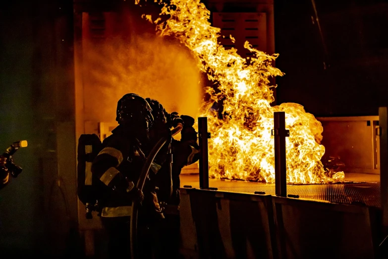 a group of people standing in front of a fire, a picture, by Daniel Lieske, shutterstock, industrial photography, soldier under heavy fire, panels, foam