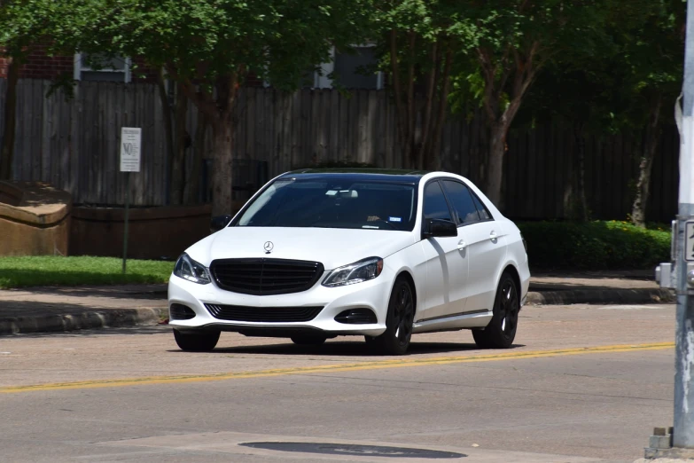 a white car driving down a street next to a parking meter, mercedez benz, fully body photo, modern very sharp photo, louisiana