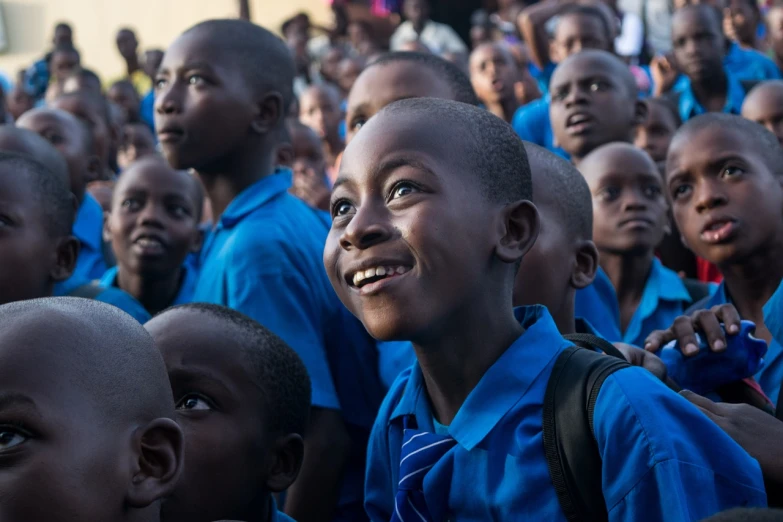 a group of children standing next to each other, happening, he is smiling, in front of a large crowd, emmanuel shiru, avatar image