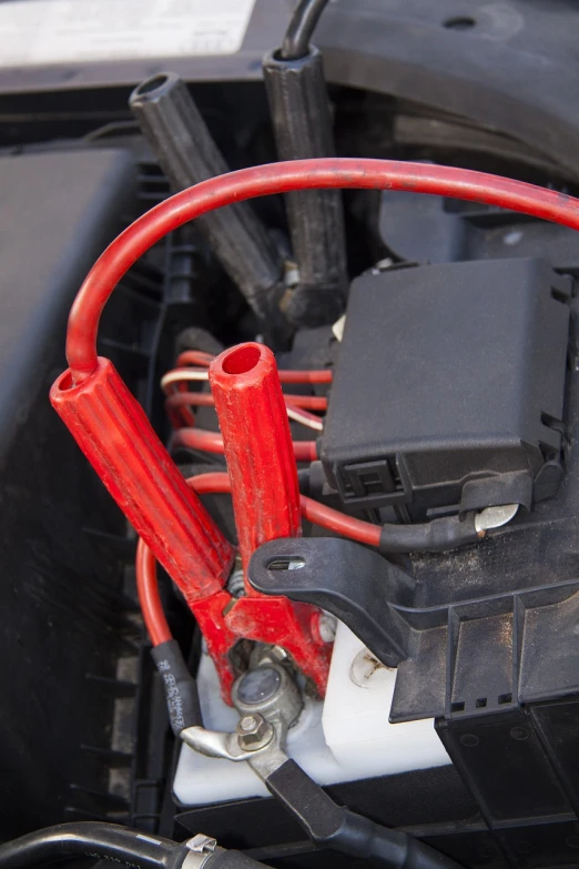 a close up of a battery in a car, a portrait, shutterstock, rubber hose style, red and black color scheme, covered with wires, high res photo