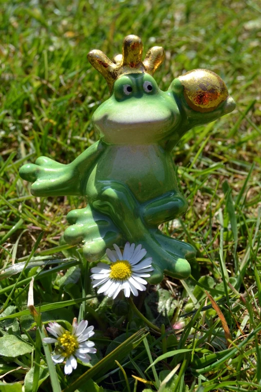 a statue of a frog with a crown on its head, a picture, inspired by Károly Brocky, pixabay contest winner, figuration libre, picking up a flower, having fun in the sun, resin miniature, bubbles ”