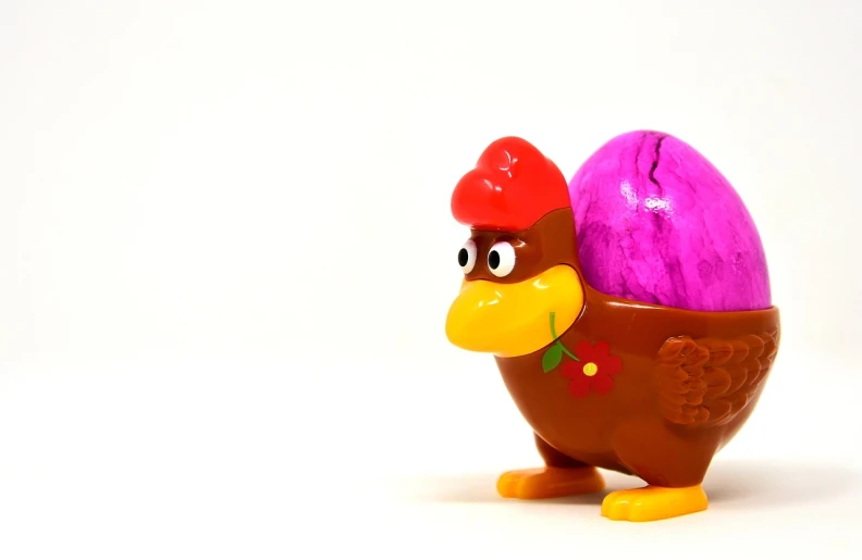 a toy chicken with a purple egg in its beak, a stock photo, inspired by Károly Patkó, plasticien, brown and magenta color scheme, the macho duck, easter, half body photo