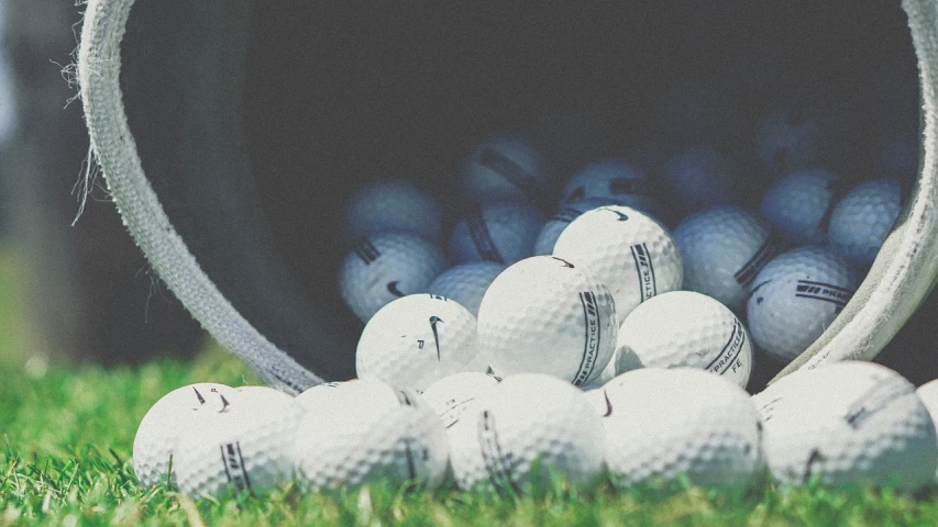 a bucket full of golf balls sitting in the grass, a picture, by Matija Jama, unsplash, avatar image, half image, swoosh, performance