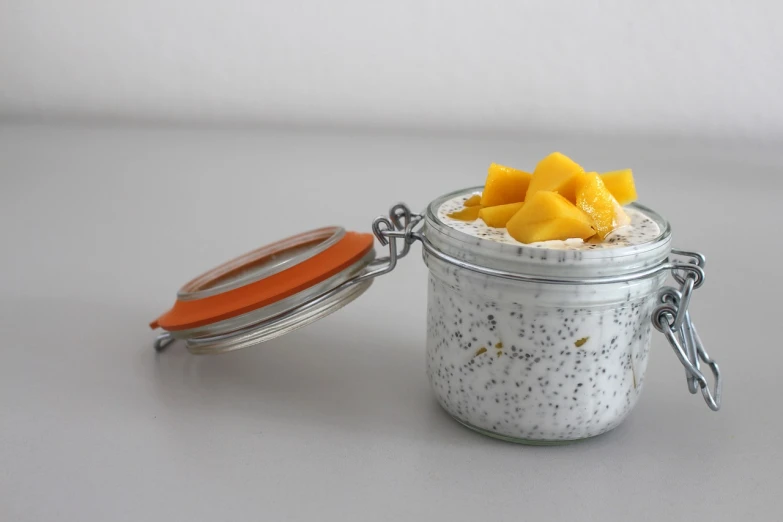 a close up of a jar of food on a table, by Eva Švankmajerová, mango, white and grey, luscious with sesame seeds, breakfast