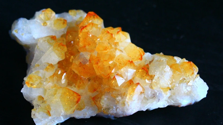 a cluster of yellow crystals on a black surface, orange and white, purity, sichuan, high quality product image”